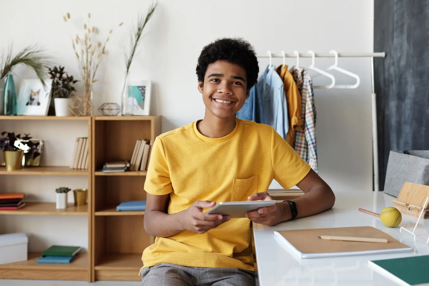 A smiling teenage boy at his desk at home