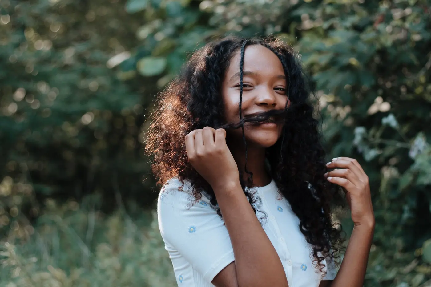 A smiling teenage girl outdoors in the summer